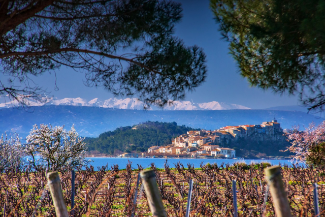 L'étang et le village de Bages avec les Pyrénées enneigées, par G. Deschamps - ADT Aude