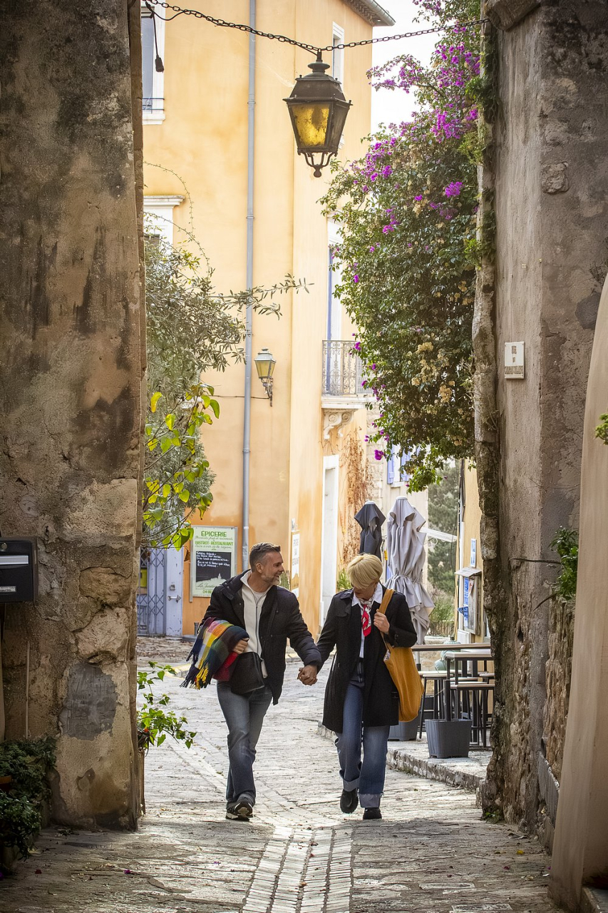 Couple en ballade dans une ruelle fleurie du village de bages - Photo de Céline Deschamps